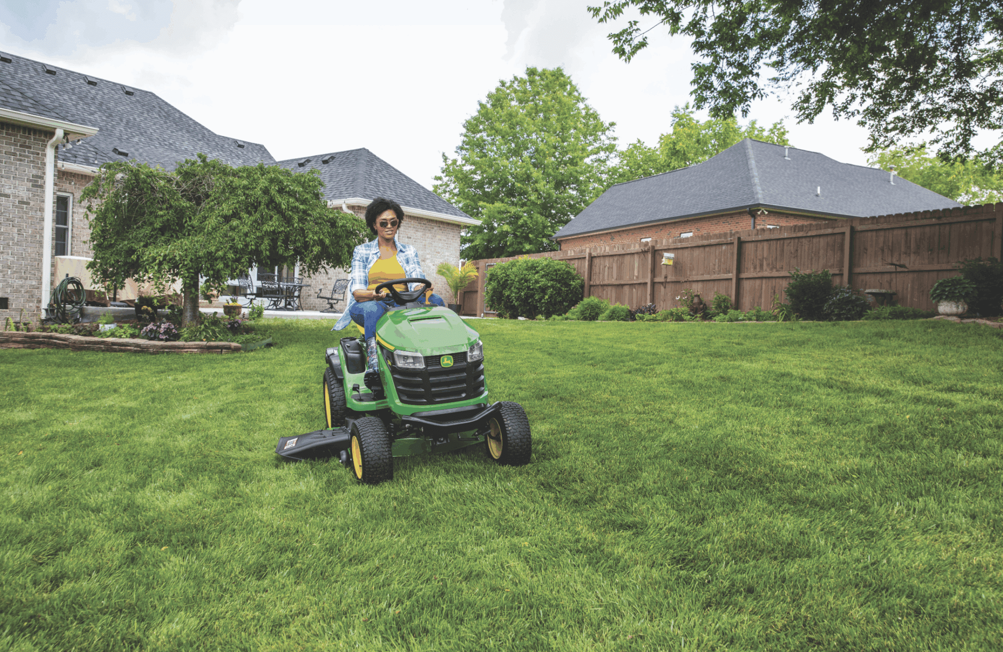 Woman cutting tractor lawn with lawn tractor
